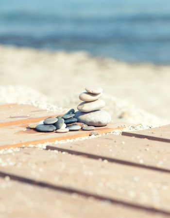 Arrangement with stones on wooden slats on the sand of a beach