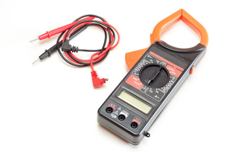 Black digital clamp meter with red and black cables, isolated