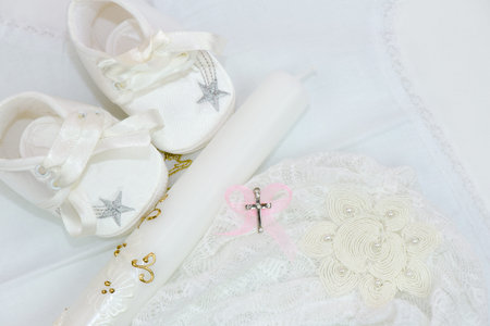 Baby shoes, candle and cross for christening