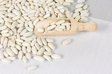 White kidney beans with wooden scoop on white background