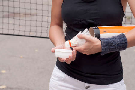 Young woman takes out shuttlecocks from their boxの写真素材