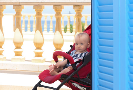 Infant baby in red trolley, outdoor picture