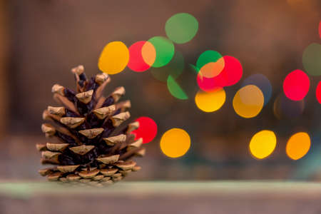 Closeup of a fir tree cone with lights in background, Christmas symbolの写真素材