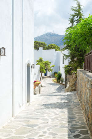 Narrow passage with white buildings and trees from Greeceの写真素材