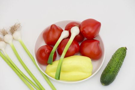 Vegetables like onion, garlic, tomatoes, pepper and cucumber on white background