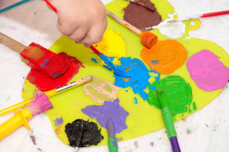 Hand of a child mixing colors on an easelの写真素材