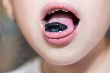 Close up of a child mouth with a skin from a grapeの写真素材