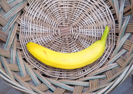 Yellow banana inside a wicker basketの写真素材