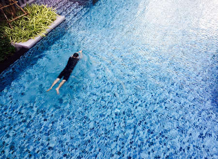 Man swimming in a poolの素材