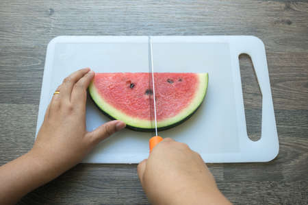 woman hand's is cutting a watermelonの写真素材