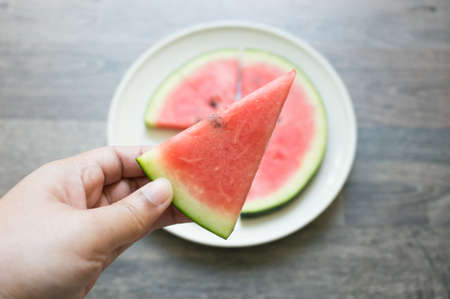 woman hand's is holding the piece of watermelonの写真素材