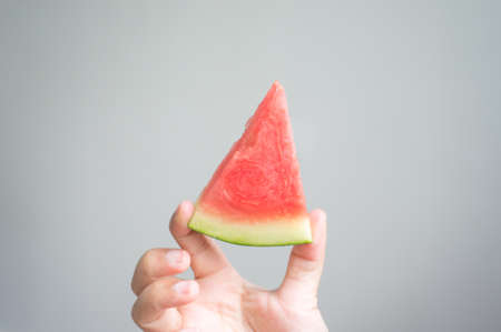 woman hand's is holding a watermelon in gray background , selective focusの写真素材