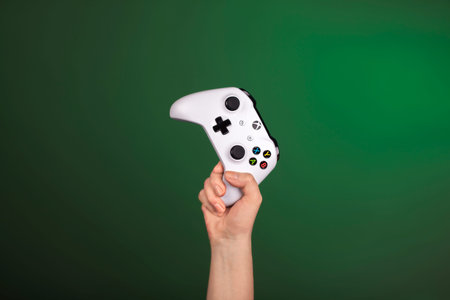 RUSSIA, MOSCOW, JANUARY 2017 Hand is holding xbox one s gamepad against a green background