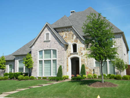 Beautiful house with a green lawn. Young trees in front of a large house.のeditorial素材