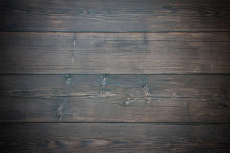A brown wall of wooden planks with tree branches and stripes. Brown background with wood texture and vignette.の写真素材