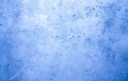 A concrete wall with dots and scuffs of blue color. Cold, blue background with cement texture.の写真素材