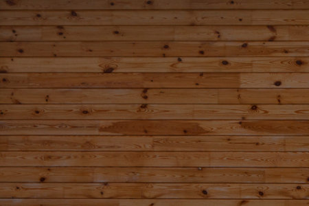 The wall is made of horizontal, brown wooden boards. Wooden texture. Brown background.