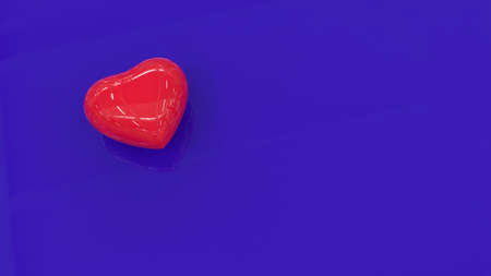 A red shiny heart on a blue reflective surface. Plastic heart on a blue background. 3D image.の写真素材