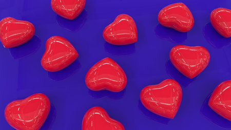 Red shiny hearts on a blue reflective surface. Lots of plastic hearts on a blue background. 3D image.の写真素材