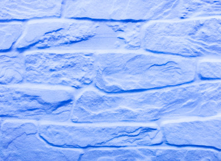 The old stone wall is blue with damage and blurring. Light blue vintage background with brick texture.の写真素材