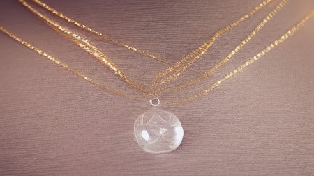 Beautiful jewelry is lying on the table. A gold chain with a precious stone. Expensive jewelry. generated AI.の素材
