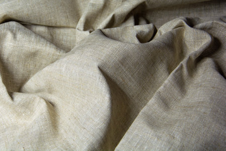 Gray crumpled fabric. The bedspread is made of coarse gray fabric. gray background.の写真素材