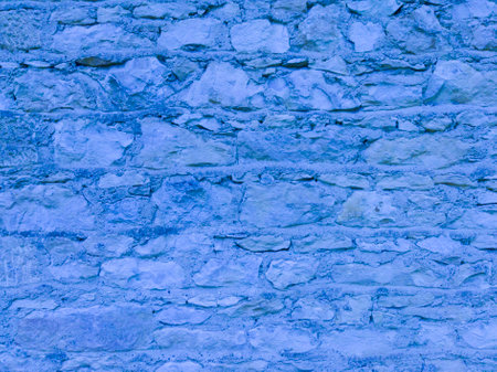 An old, blue wall made of stone and cement. Blue, stone background. Ancient ruins. Stone texture.の写真素材
