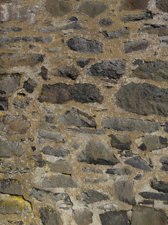 An old gray wall made of stone and concrete. Gray stone background. Brick texture. Brickwork. Vertical image.の写真素材