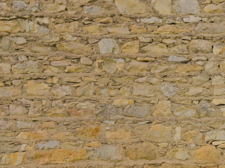 An old yellow wall made of stone and cement. Yellow, stone background. Stone texture.の写真素材