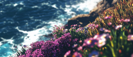 Vibrant wildflowers bloom on rugged coastal cliffs at sunrise near the oceanの素材