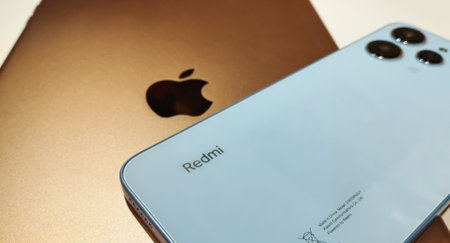 Gold iPad and Xiaomi Redmi 12 Sky Blue color. Close-up. Concept of Confrontation between Apple and Xiaomi. Stock editorial photo. 16.10.2023 Ukraine. Kyivのeditorial素材