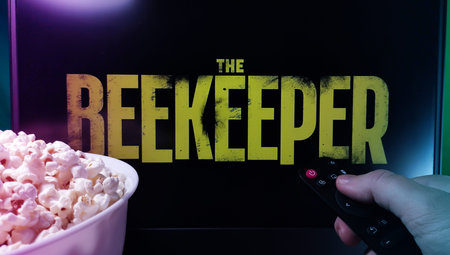 Kyiv. Ukraine. 11/10/2023: Person watching The Reekeeper on TV with popcorn and remote control....