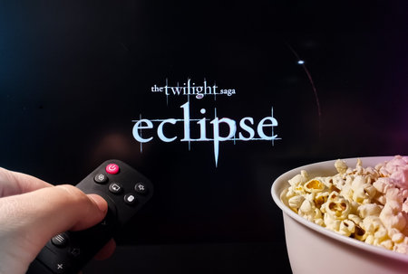 Kyiv. Ukraine. 12/11/2023: Person watching The Twilight Saga: Eclipse with popcorn and remote...