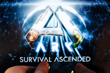 A gamer plays ARK: Survival Evolved with a gamepad. Stock editorial photo with the game logo....