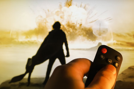 The viewer watches the film Dune 2 with the remote control in his hands. Explosion scene on the planet Arakis with Paul Atreides. Stock editorial photo of watching a movie. Ukraine, Kiev. 04.14. 2024のeditorial素材