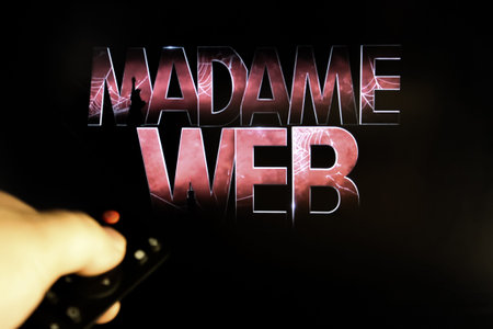 The viewer watches the film Madame Web with the remote control in his hand. Stock editorial viewing...