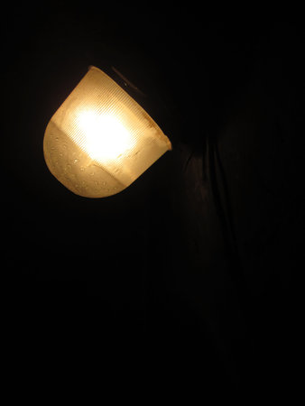 A vintage light fixture casts a warm glow in a dimly lit room, illuminating the surroundings with a...