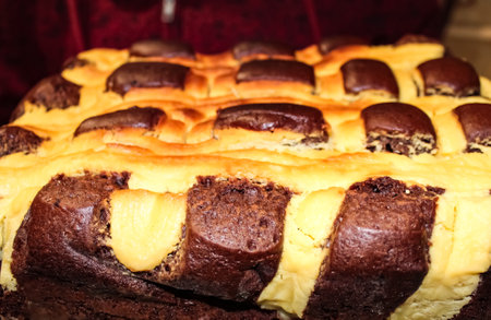 This delightful marbled cake features a striking chocolate and vanilla design, resting on a kitchen counter in the warm afternoon light, ready to be enjoyed.の写真素材