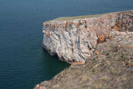 A high rocky coastline a cliff in the sea a lake and fog over the waterの写真素材