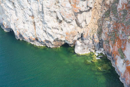 A high rocky coastline a cliff in the sea a lake and fog over the waterの写真素材