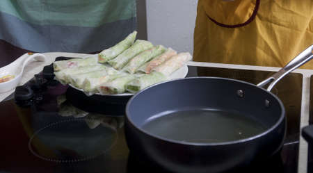 Chef giving cooking classes in kitchen Fried spring rolls tasty healthy dishes with vegetables Vietnamese cuisineの写真素材