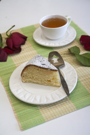 Morning biscuit cake with cup of tea on white