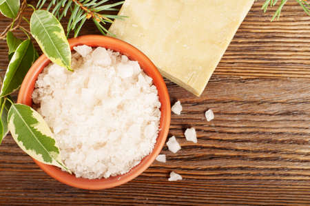 Aromatic bath salt in a clay cup and soap on a wooden backgroundの写真素材