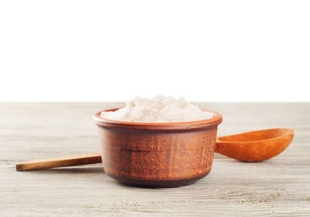 Aromatic bath salt in a clay cup and wooden spoonの写真素材