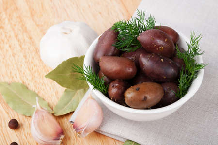 Black salted olives and dill in a white dishの写真素材