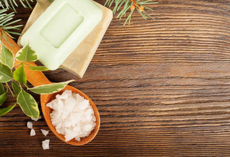 Aromatic bath salt in a wooden spoon and bars of soapの写真素材