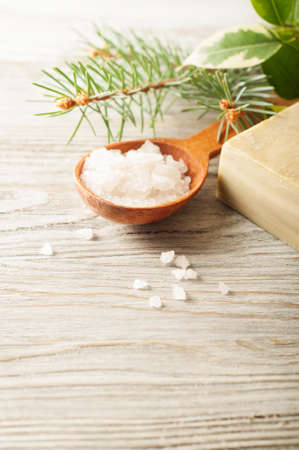 Aromatic bath salt in a wooden spoon, pine branch and soapの写真素材