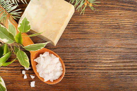 Aromatic bath salt in a wooden spoon and bar of soapの写真素材