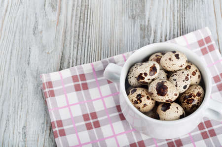 Quail eggs in a white plate on a wooden backgroundの写真素材