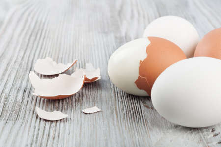 Boiled hen eggs and eggshell on a wooden backgroundの写真素材